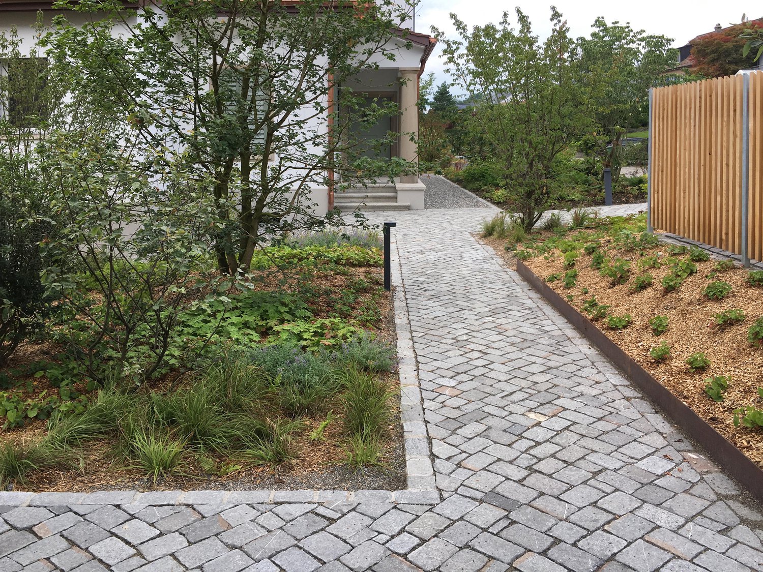 Landschaftsgarten verbindet Villa mit zwei modernen Neubauten